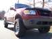 2002 Ford Sport Trac - A red 2002 Ford Sport Trac is parked outside with large off-road tires and a bug deflector.