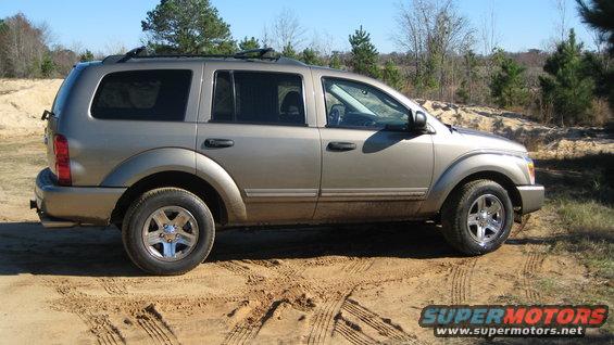 Tan 2004 Dodge Durango SUV parked on dirt road, side view