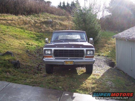 Front view of a brown Ford F-Series truck parked on a gravel driveway next to a shed