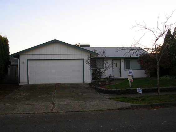 Suburban house with white siding, attached garage, and a driveway