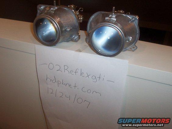 Pair of headlights with handwritten note reading "-02 Reflexgti - hidplanet.com 12/24/07"