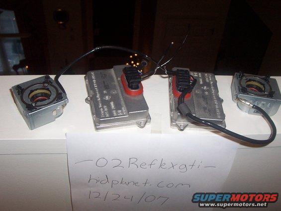 Two HID ballasts and two igniters on a shelf. Paper in front has writing: '-02 Reflexgti- hidplanet.com 12/24/07'