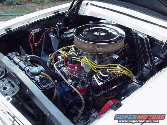 Engine bay of a classic Ford, showing V8 engine, air cleaner, radiator, and wiring