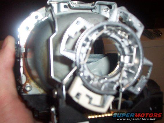 Close-up of a car headlight assembly, held by a hand