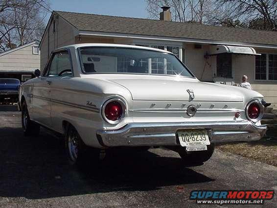 1960 Ford Falcon, rear 3/4 view. Blue car in background. License plate QQ-8239