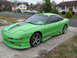 1994 Ford Probe - A lime green 1994 Ford Probe with a custom body kit and racing stripes is parked on a concrete driveway.