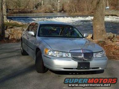Silver 2002 Lincoln Town Car parked by a river