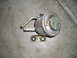 1986 Toyota Hilux - A metal vacuum actuator, identified by 'TOYOTA' text, is shown against a concrete surface.