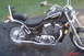 2002 Suzuki VL 1500 Intruder Classic - A black Suzuki motorcycle is parked on a paved surface with grass in the background.