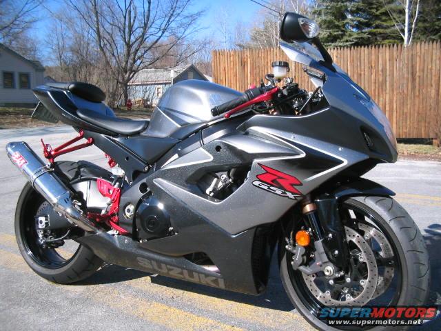 Gray and black Suzuki GSX-R motorcycle with red accents, parked on a street
