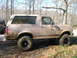 1996 Ford Bronco - This 1996 Ford Bronco is heavily covered in mud, suggesting off-road use.