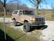1996 Ford Bronco - This mud-splattered Ford Bronco is ready for off-road adventures, parked outside on a sunny day.