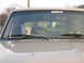 1996 Ford Bronco - A dog sits in the passenger seat, looking out the windshield of a tan vehicle.