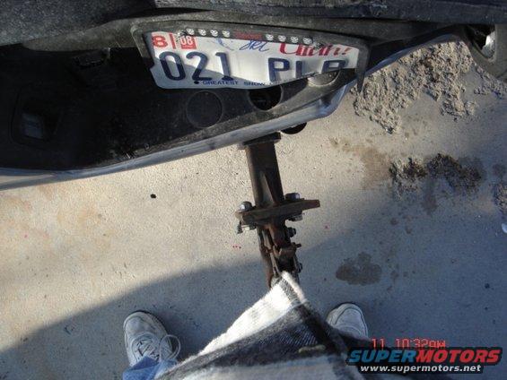 Rear bumper section with license plate and a jack attached