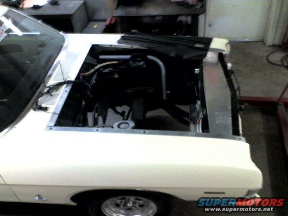 White 1963 Ford Fairlane with hood open, showing engine bay and radiator. Front view