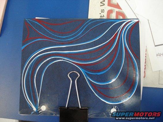 Dark blue surface with red, white, and blue pinstriping. A binder clip is attached