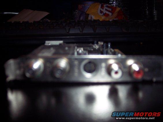 Close-up of RCA inputs on an audio amplifier, with some items in the background