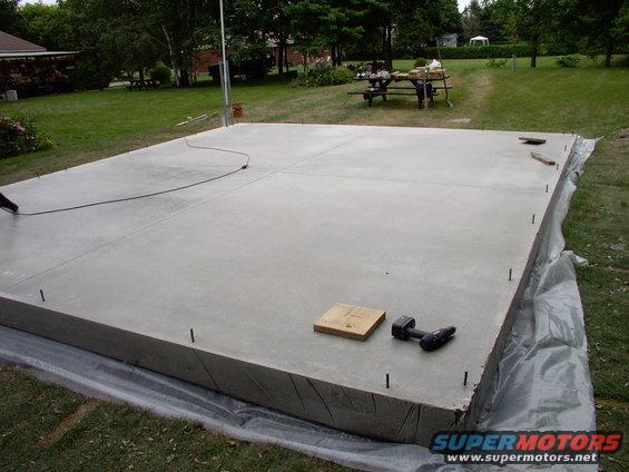 img_0064.jpg Forms off, relief cuts in, J-bolts installed. Note the conduit pipes in the far left corner. That's where the electrical service and extra conduit is going.