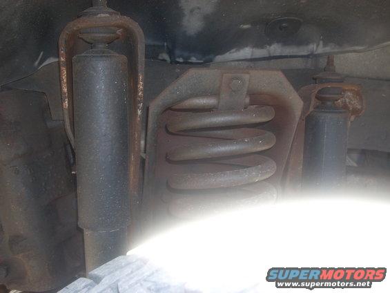 Close-up of front suspension with shock absorber and coil spring