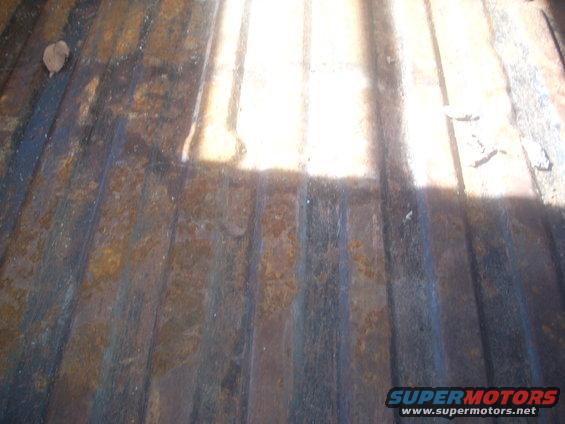 rusted truck bed with ribbed floor and a leaf