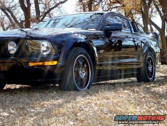 Black 2005 Ford Mustang GT parked outdoors with trees in the background