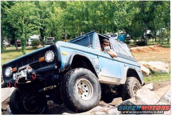 Blue 1976 Ford Bronco navigating rocky terrain
