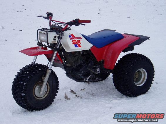 Honda SX three-wheeler ATV with red fenders and white gas tank in snow