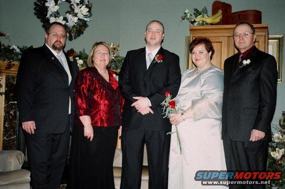 Five people in formal attire posing for a photo indoors