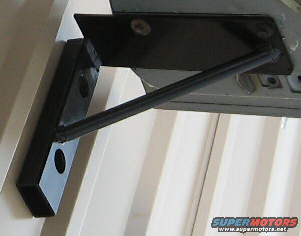 Close-up of a black metal bracket attached to a vehicle's frame