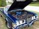 1973 Mercury Cougar - The front of a blue 1973 Mercury Cougar convertible is shown with its hood open, revealing the engine bay.