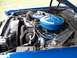 1973 Mercury Cougar - The engine bay of a blue vehicle is shown with various engine components and hoses.
