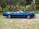 1973 Mercury Cougar - A blue 1973 Mercury Cougar convertible is parked on a grassy area with trees in the background. The "Cougar" script is visible on the fende…