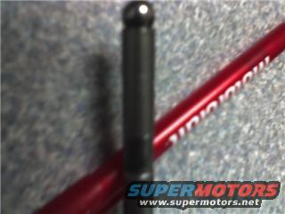 Black metal rod with a ball end, crossed by a red pen with white text