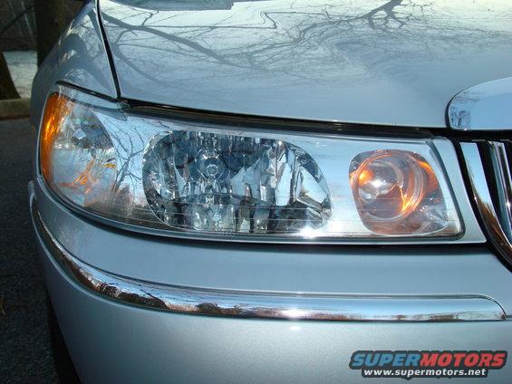 Front corner of a 2002 Lincoln Town Car showing headlight and chrome grille detail