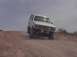 1992 Ford Bronco - This lifted 1992 Ford Bronco navigates a dusty, off-road incline under a hazy sky.