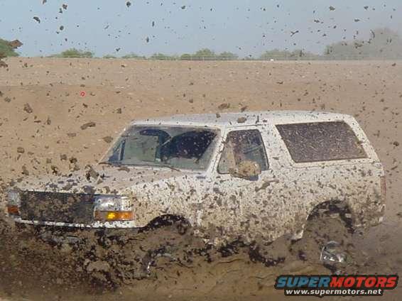 1992 Ford Bronco driving through deep mud