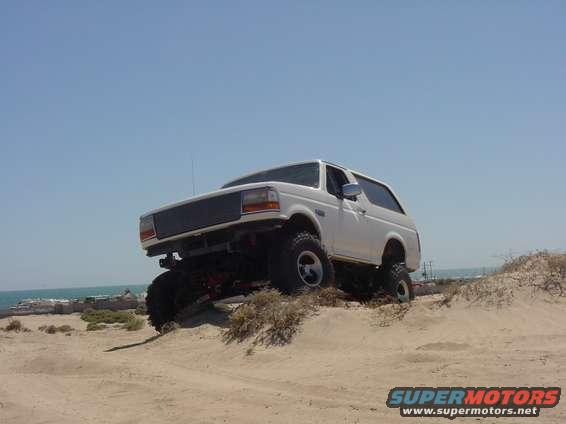White 1992 Ford Bronco on sand dunes