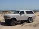 1992 Ford Bronco - This lifted 1992 Ford Bronco is parked on a sandy terrain near the coast.