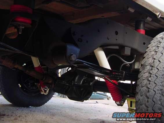 1992 Ford Bronco suspension with red and white shocks, leaf springs, and a differential
