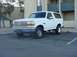1992 Ford Bronco - A white 1992 Ford Bronco is parked in an asphalt lot with a building in the background.