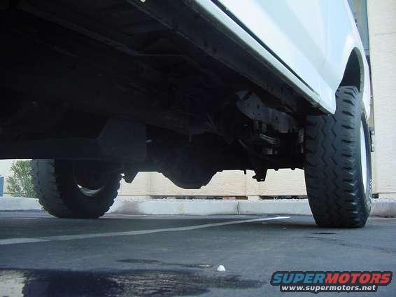Underbody view of a truck, showing the frame, suspension, and rear tire