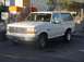 1992 Ford Bronco - A white 1992 Ford Bronco is seen from a three-quarter front angle at a gas station.