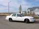 1999 Ford Crown Victoria - A white 1999 Ford Crown Victoria is parked on a suburban street.