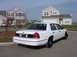 1999 Ford Crown Victoria - This white 1999 Ford Crown Victoria is shown from the rear in front of a suburban house.