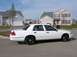 1999 Ford Crown Victoria - White Ford Crown Victoria sedan parked on a residential street with houses in the background.