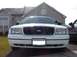 1999 Ford Crown Victoria - Front view of a white 1999 Ford Crown Victoria, its grille and headlights, with an Illinois license plate visible.