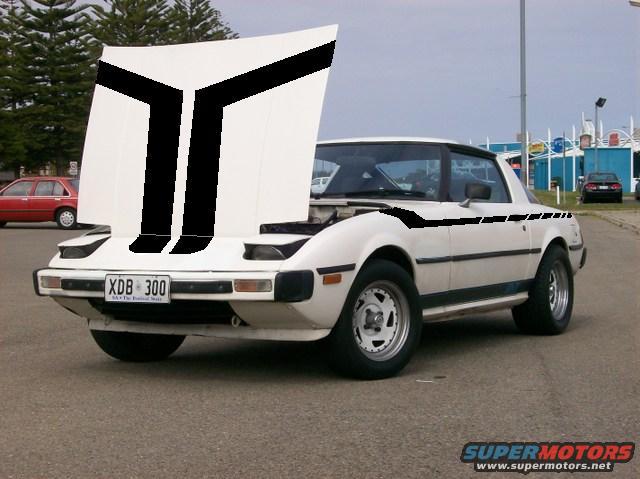White Mazda RX-7 with black hood and side stripes, hood open, front 3/4 view