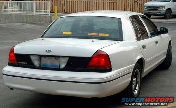 White sedan, rear 3/4 view, showing taillights and black trim panel