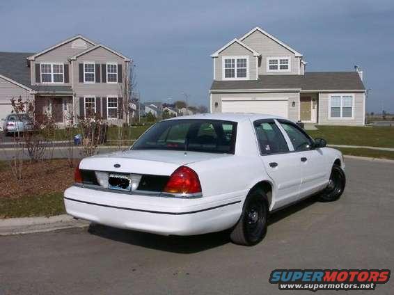 White 1999 Ford Crown Victoria parked in front of a suburban house