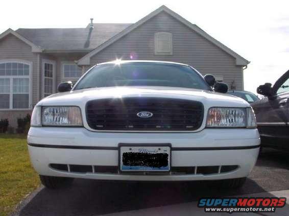 1999 Ford Crown Victoria front view, parked in driveway. Another vehicle is visible to the right